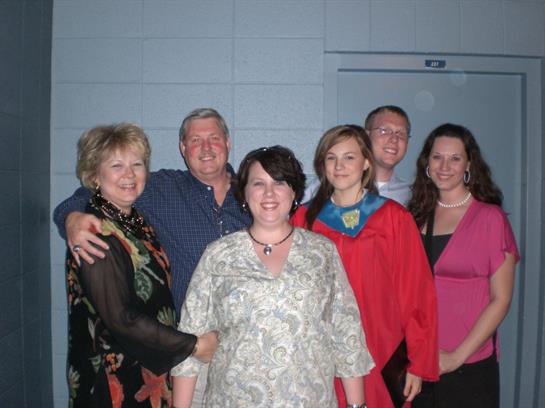 Loved ones gather together to celebrate a recent graduate in a community center.