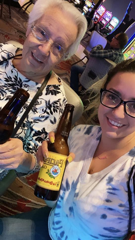 Excitement fills the air as a grandmother and her granddaughter share drinks at a casino.