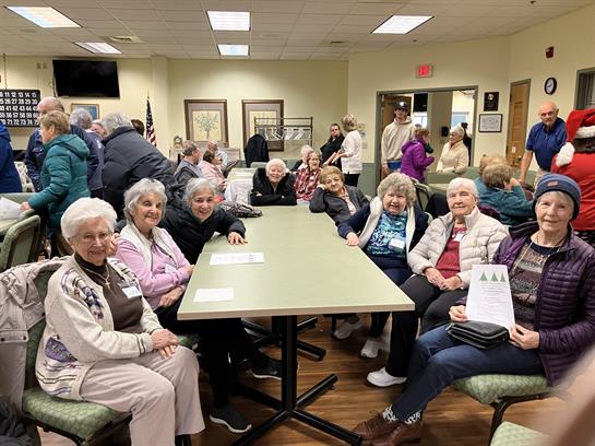 A group of elderly people sitting around a table