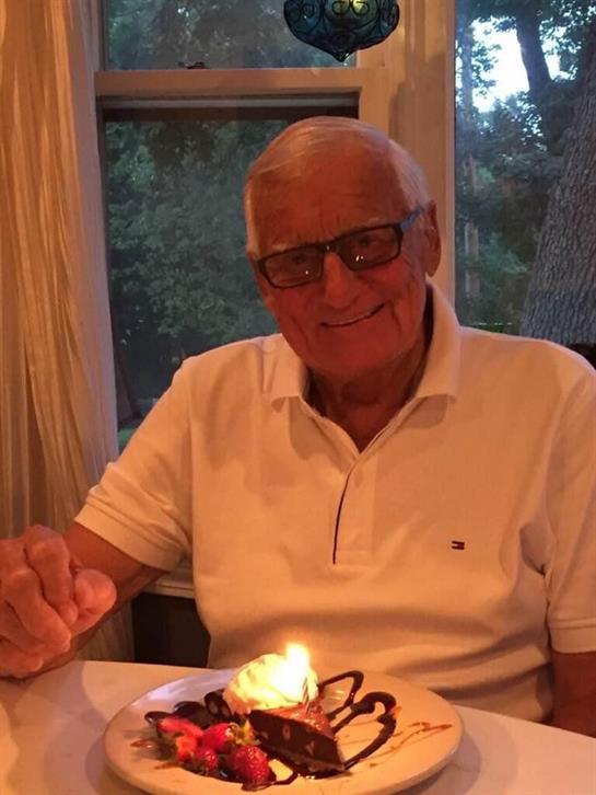 A man sitting at a table with a cake