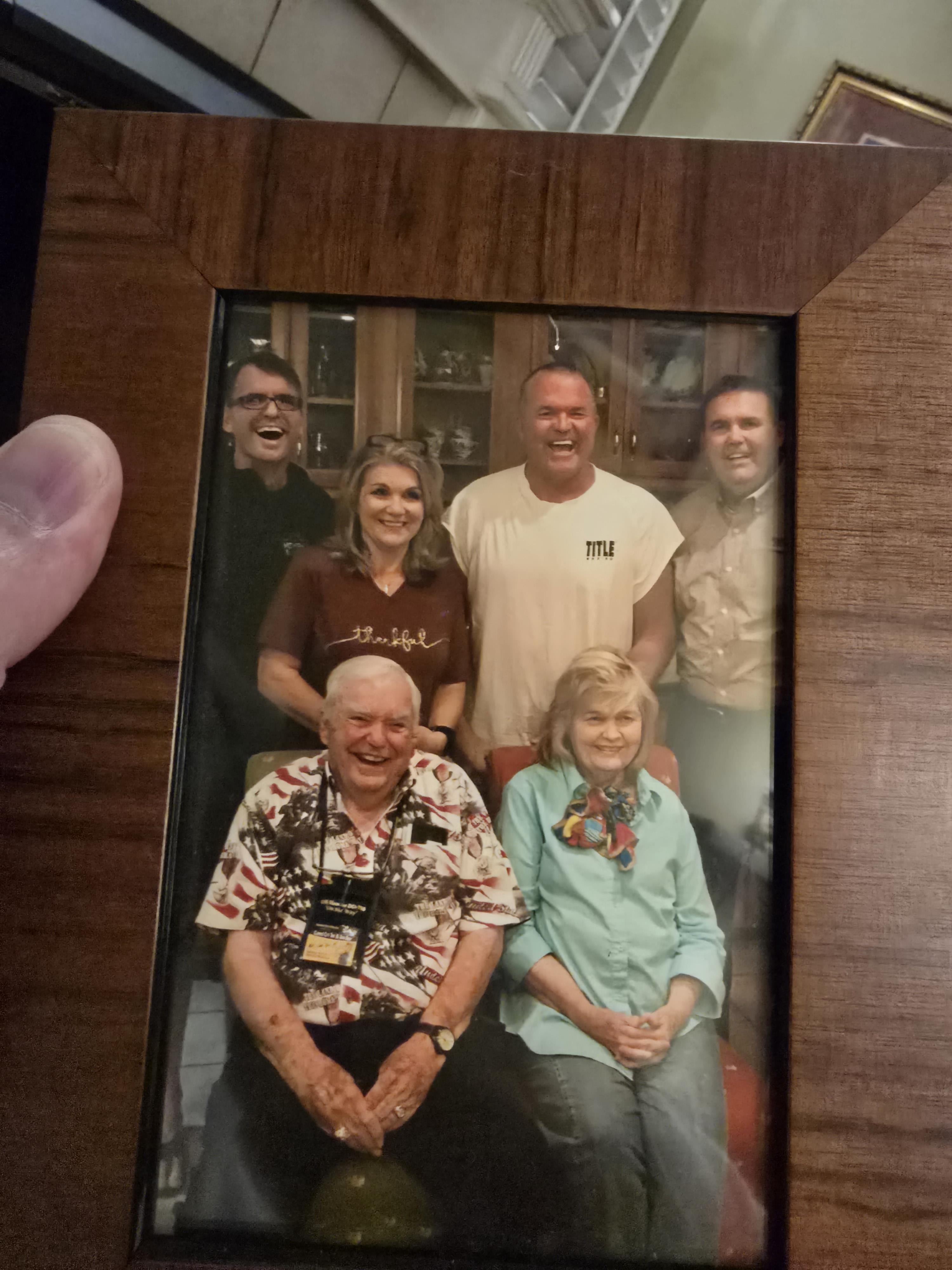 Relatives gather in a warm living room, sharing laughter and smiles during a family reunion.