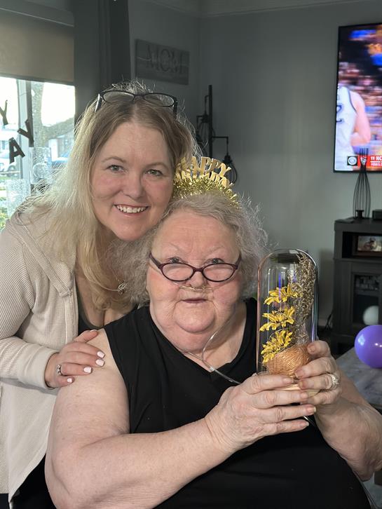 A woman holding a glass bell and a woman holding a flower