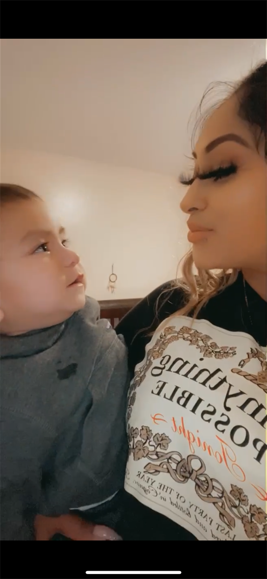 A mother and her baby share an intimate moment while looking into each other's eyes indoors.