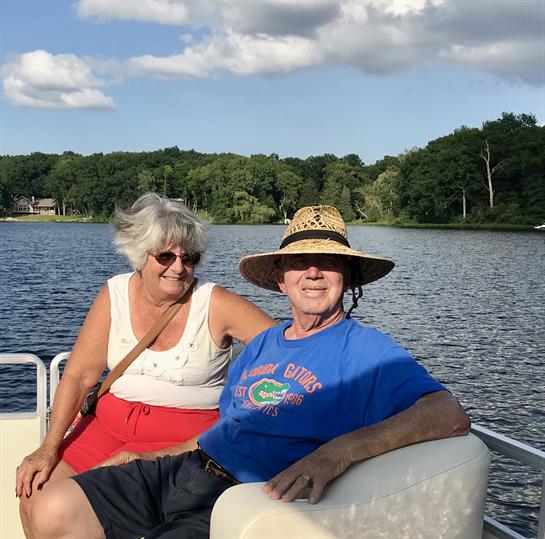 Two women relax on a boat, smiling and enjoying the warm weather by the lake.