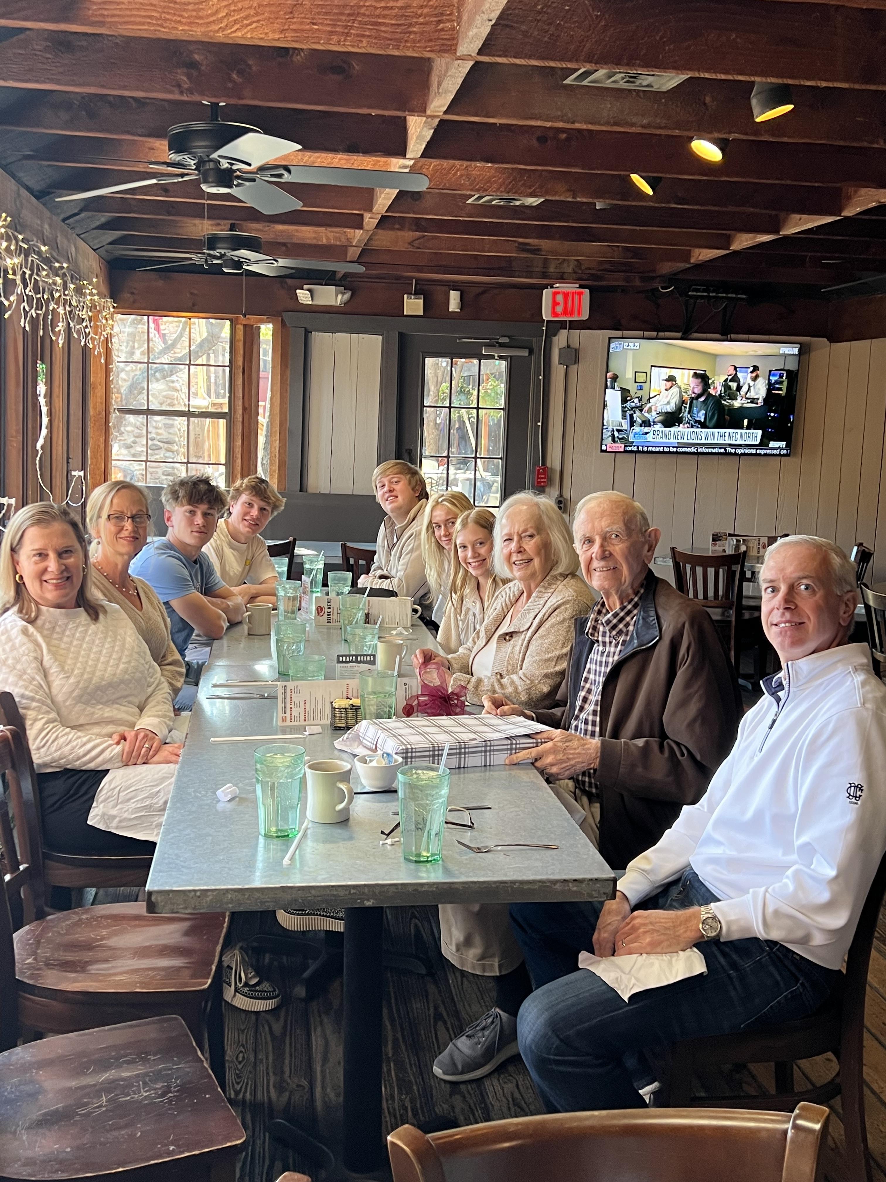 A large family enjoys brunch together at a rustic eatery, sharing laughs and stories.