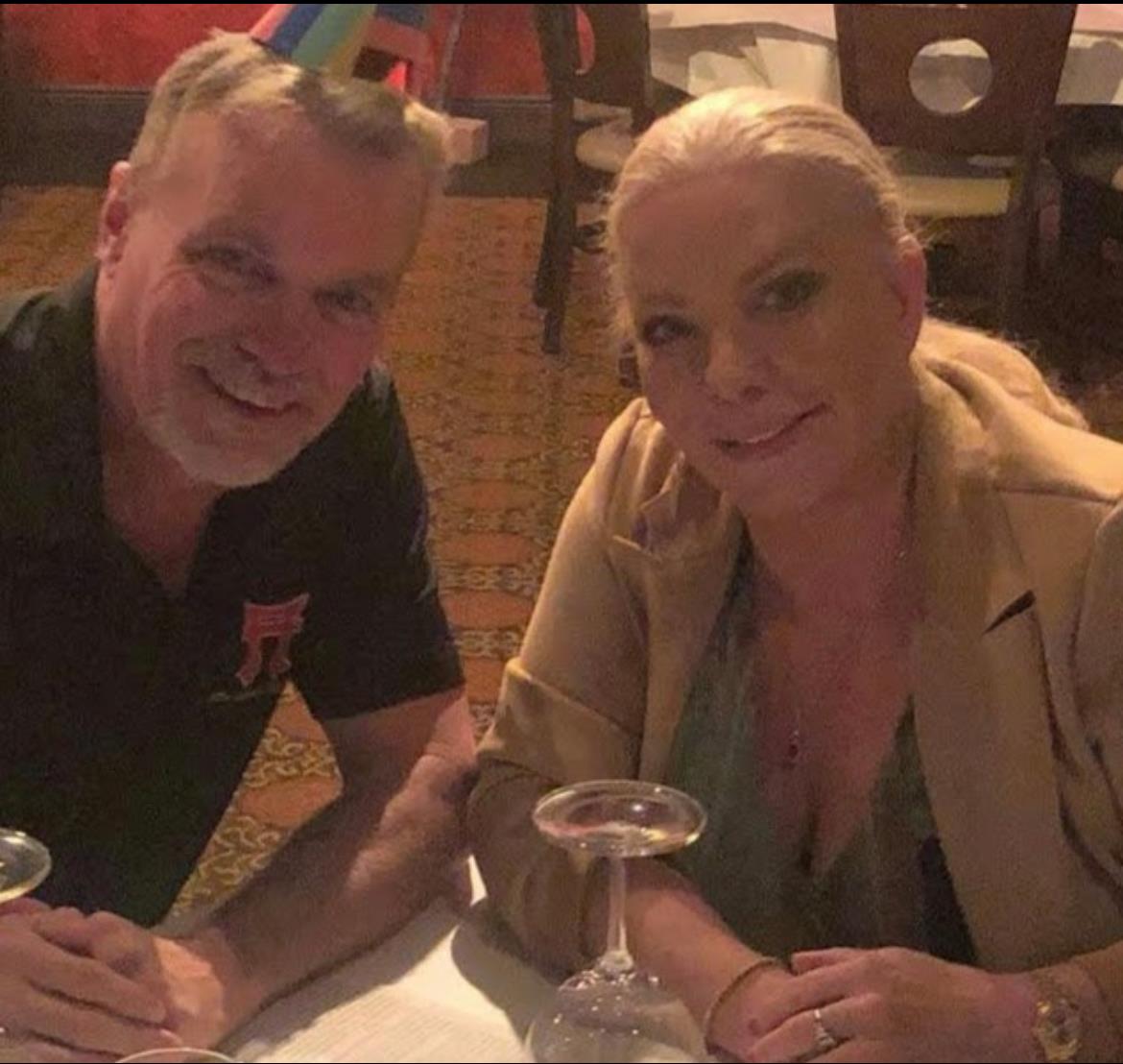 A couple enjoys a festive dinner together at a restaurant, celebrating with smiles and drinks.