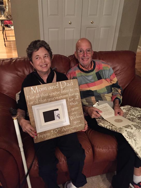 Family hosts a cozy gathering to celebrate a couple's 50th wedding anniversary, filled with love.