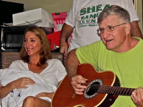 Friends enjoy a relaxed afternoon together while one plays guitar and others share smiles.