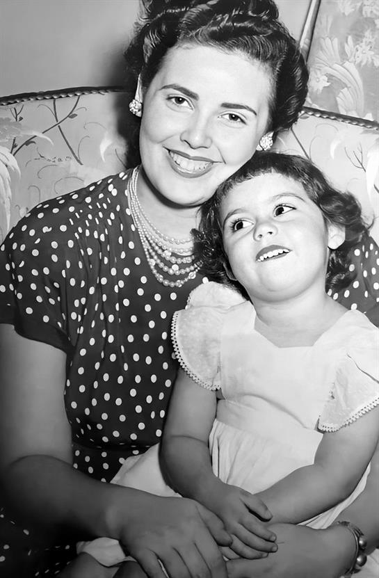 A mother and her young daughter enjoy a tender moment together, radiating happiness and love.