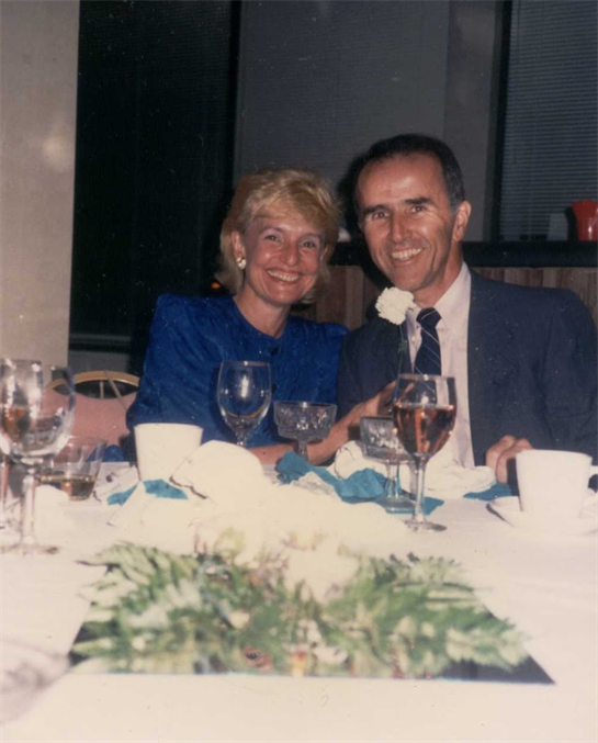 A man and woman sitting at a table with wine glasses