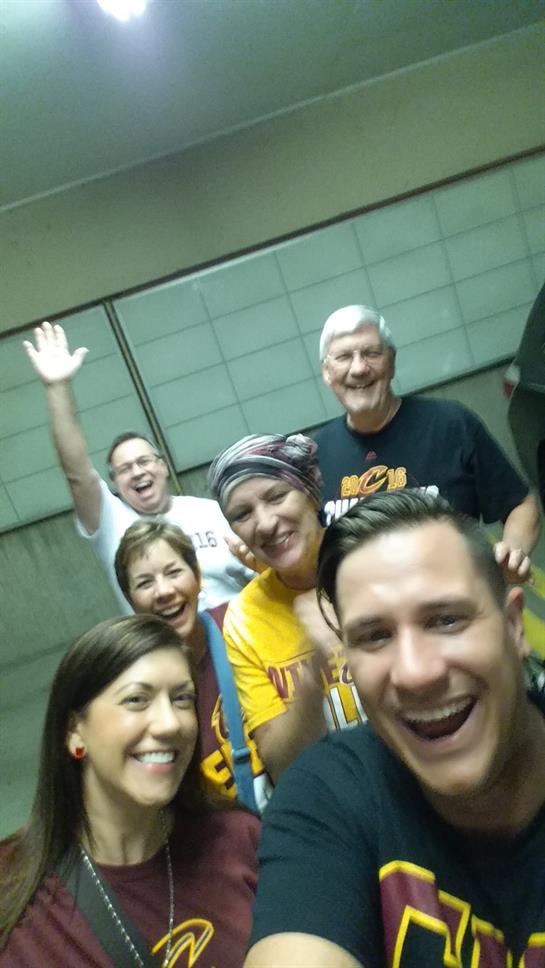 Friends are smiling and waving as they enjoy their time together in a lively atmosphere.