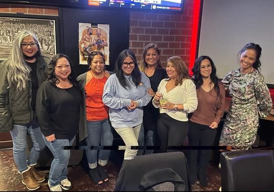 Friends smile and pose together in a relaxed restaurant atmosphere, enjoying their time.