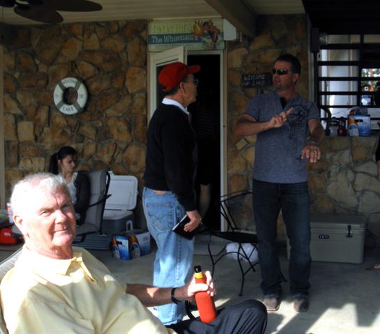 Friends share stories and laughter on a sunny patio, enjoying drinks and each other's company.