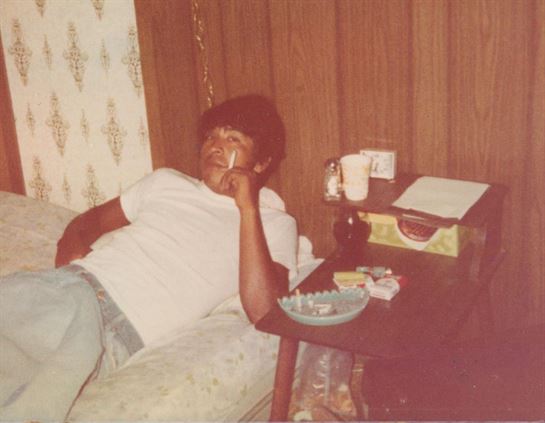A man lying on a couch smoking a cigarette