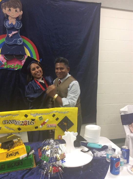 A graduate wearing a cap and gown celebrates with a family member at a joyful event.