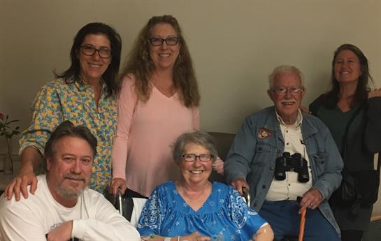 Loved ones gather in a warm living room, sharing laughter and cherished moments together.