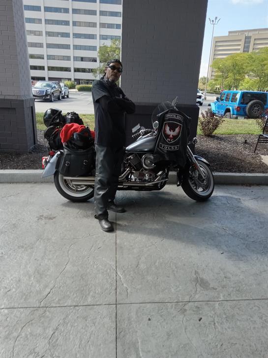 A man standing next to a motorcycle
