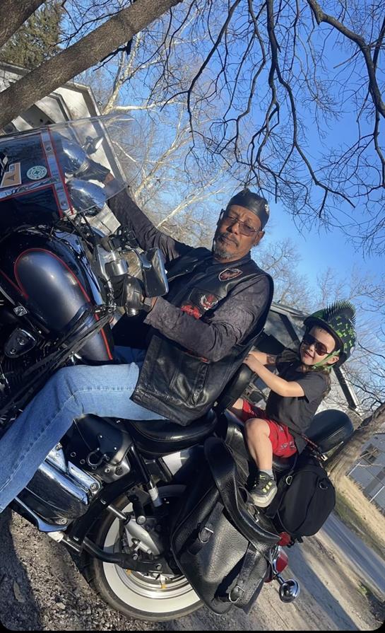 A man and boy sitting on a motorcycle