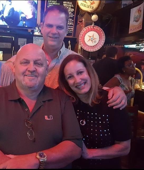 Friends gather at a bustling bar, laughing and enjoying their time together during the evening.