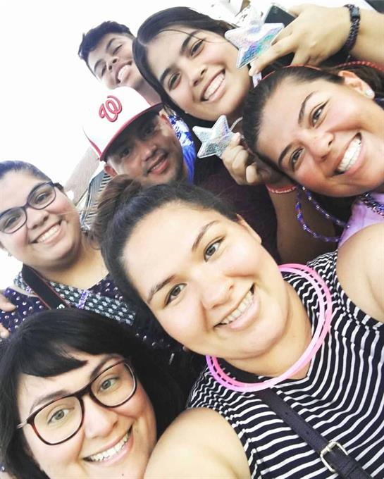 A group of friends gathers for a joyful moment, sharing smiles and laughter at an outdoor event.