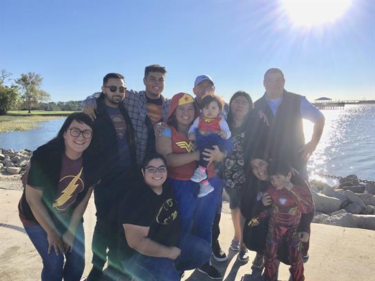 Family gathers for a joyful outing, featuring costumes, laughter, and the bright sun by the lake.
