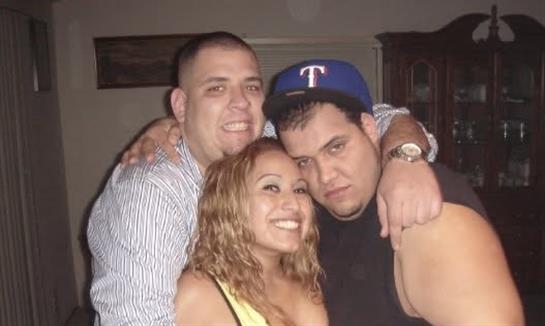 Three friends pose together, smiling and enjoying each other's company in a lively atmosphere.