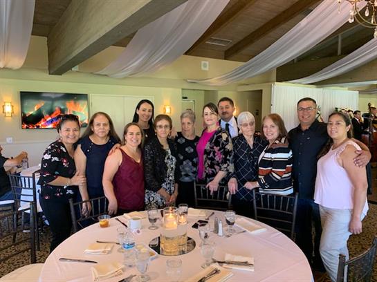 Group of friends and family gathered in a decorated restaurant for a celebration.