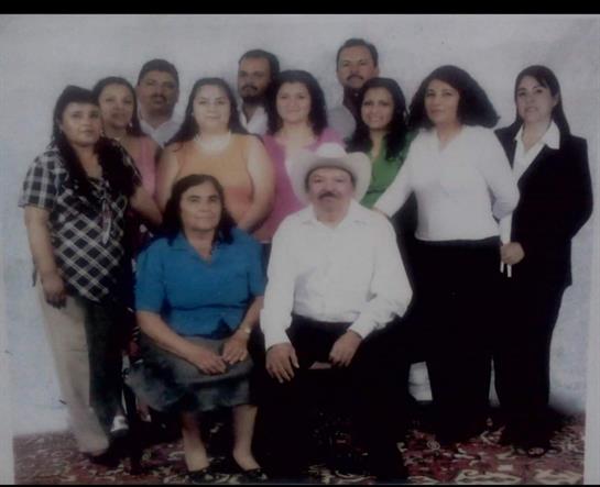 A large group of family members poses together for a studio portrait, showcasing unity and joy.