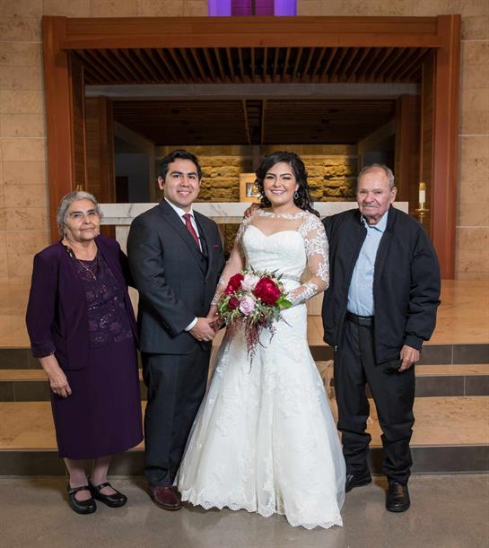 Joyful couple poses with their parents after exchanging vows in an elegant setting.