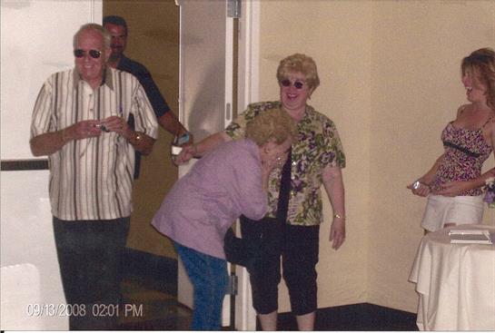Friends greet each other warmly during a joyful reunion at a banquet hall setting.