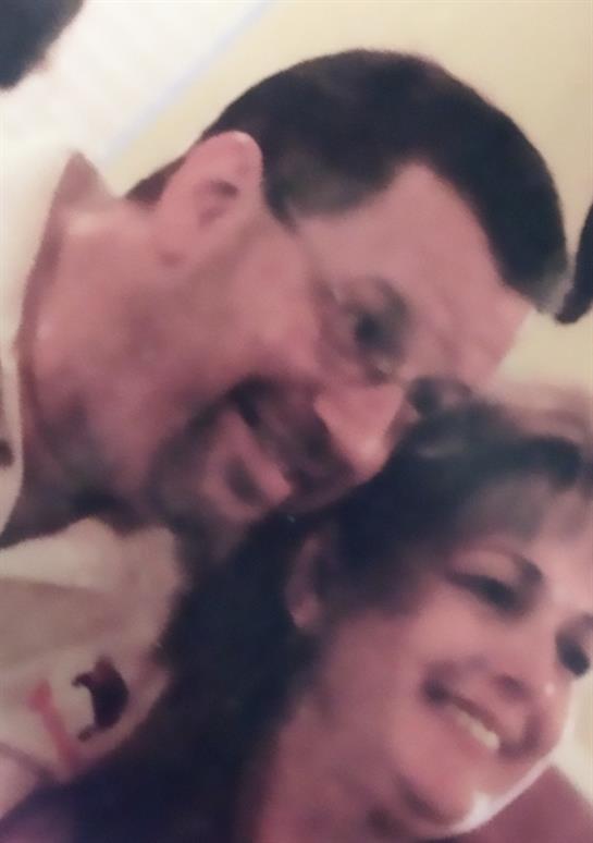 A man and woman smile happily while enjoying each other's company at an event.