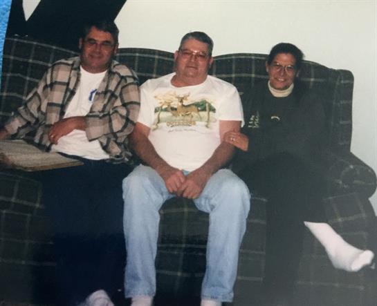 Three friends relax together on a couch, enjoying each other's company in a warm atmosphere.