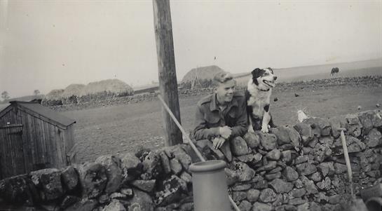 A man and dog sitting on a wall