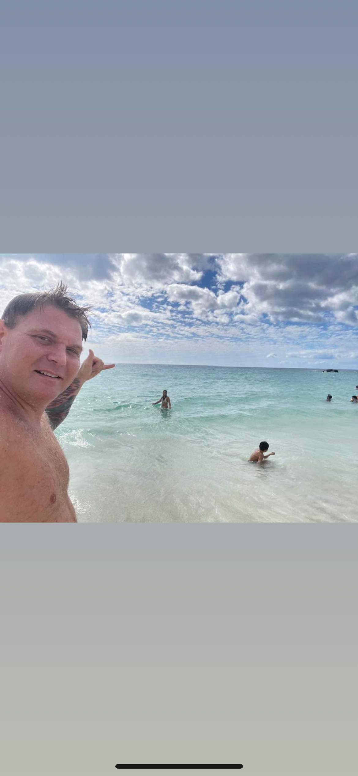 People are swimming and enjoying the beautiful beach on a sunny day with clear water and clouds.