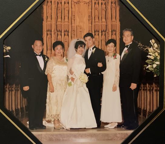 Family gathers for a wedding celebration in a stunning church adorned with flowers.