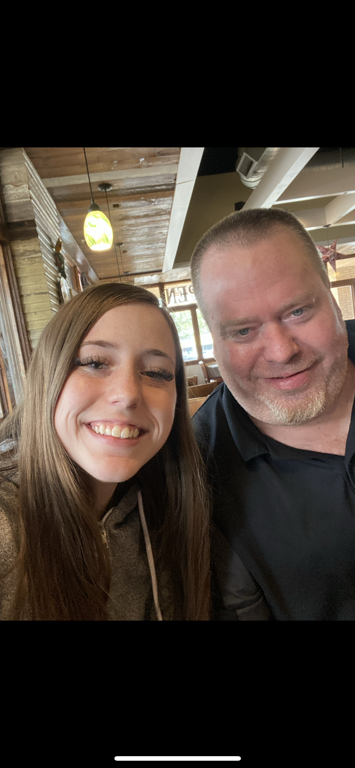 Two friends enjoy a cheerful moment together while dining in a relaxed restaurant setting.