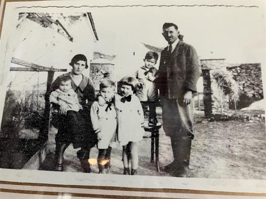 A family poses for a portrait outdoors in their garden during the early 1900s.