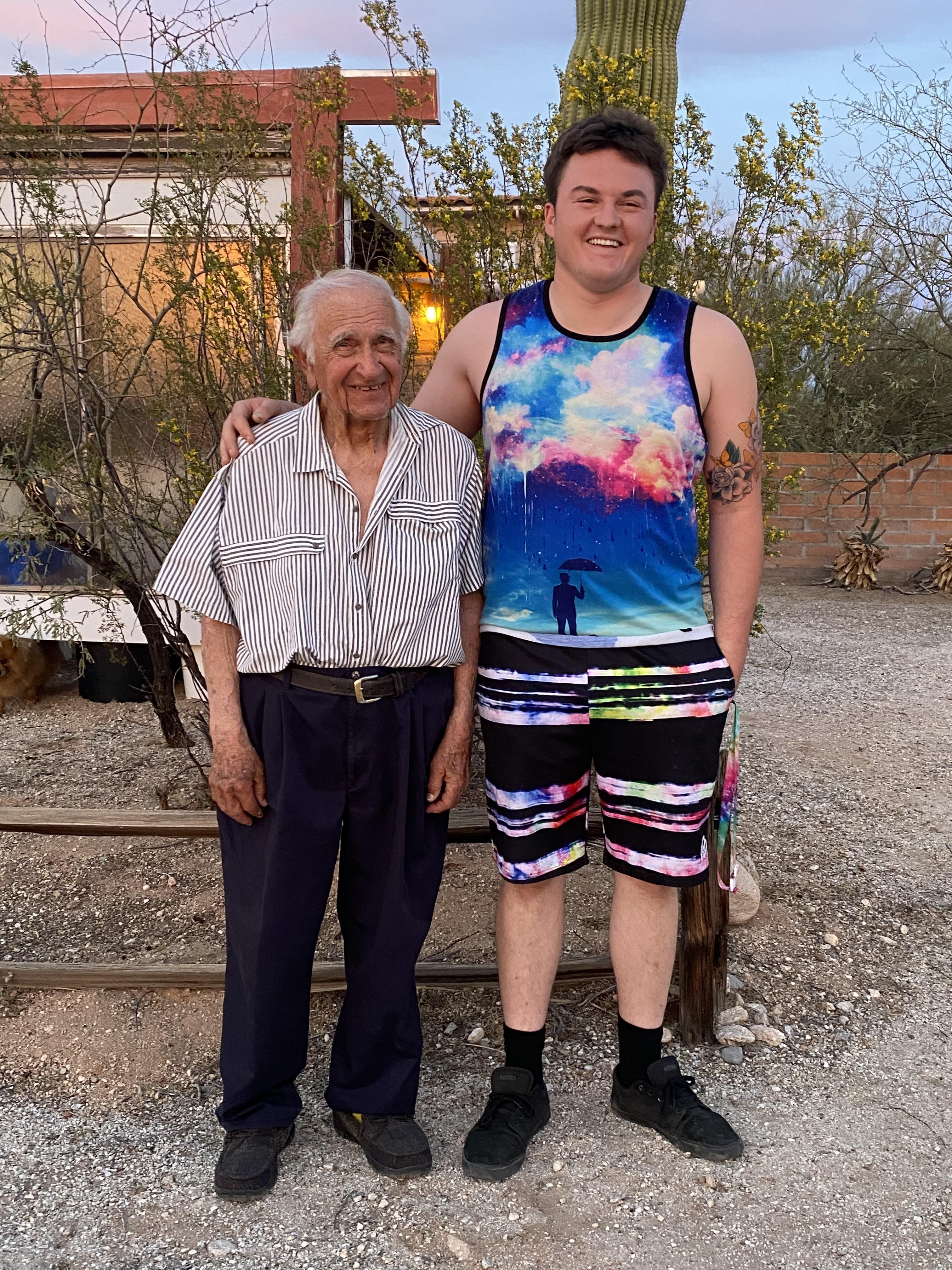 Two men stand side by side, enjoying each other's company in a desert landscape.