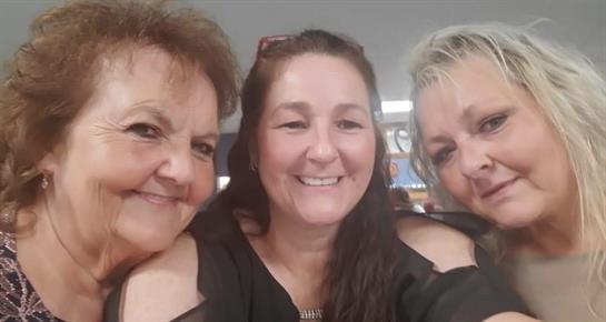 Three friends smile while taking a selfie, capturing their joyful atmosphere and strong bond.