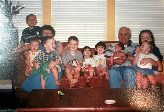 Family members enjoy quality time together on a couch, surrounded by laughter and smiles.