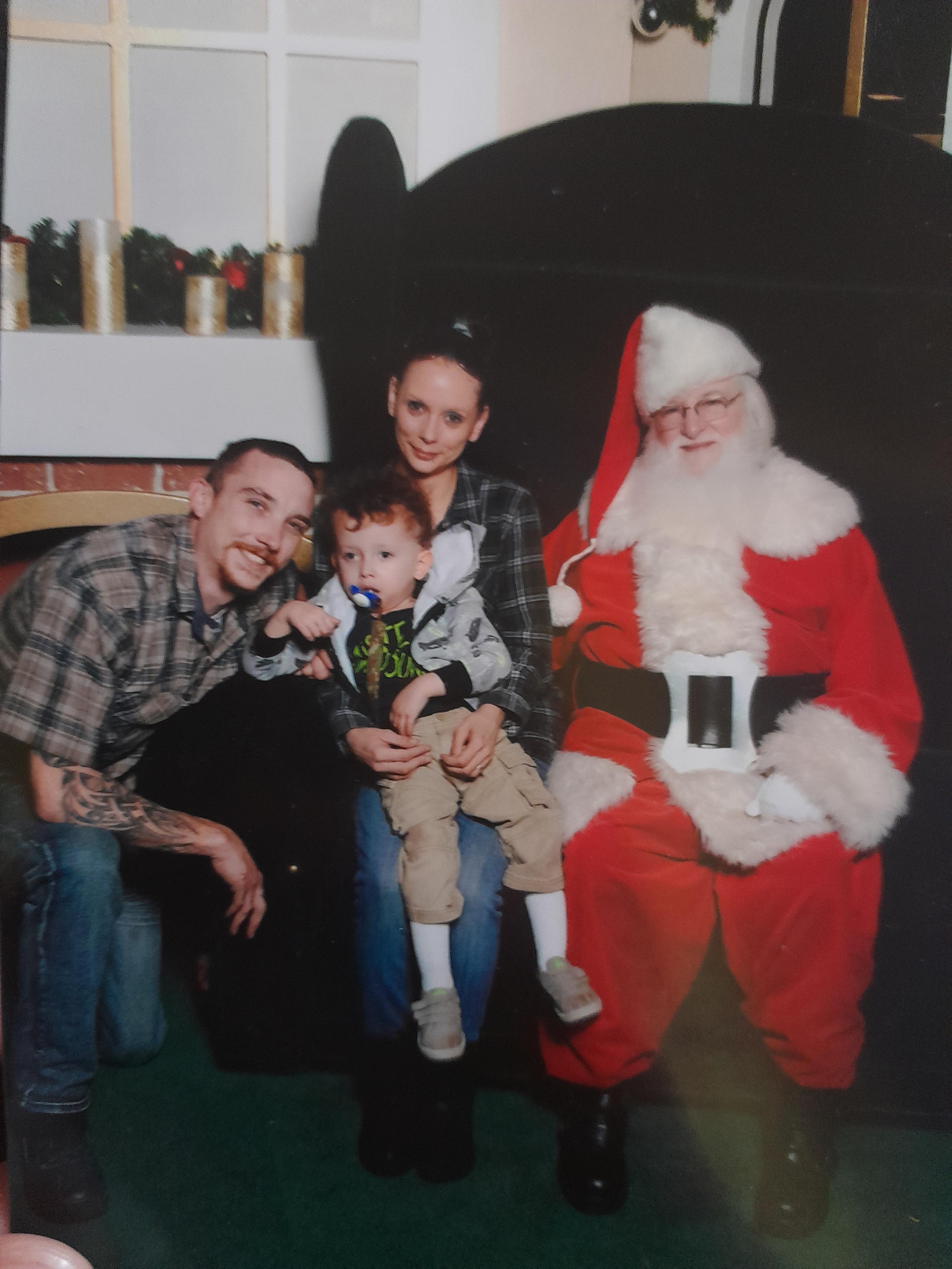 A family poses with Santa Claus, capturing joyful holiday spirit in a festive setting.