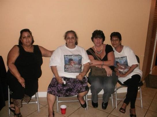 Four women enjoy a lively moment together while sitting in a cozy indoor space.