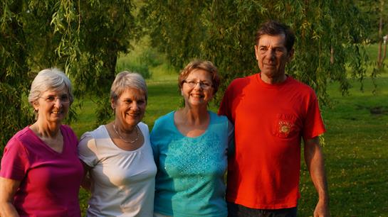 Four friends are gathered in a park, enjoying a sunny day filled with joy and companionship.