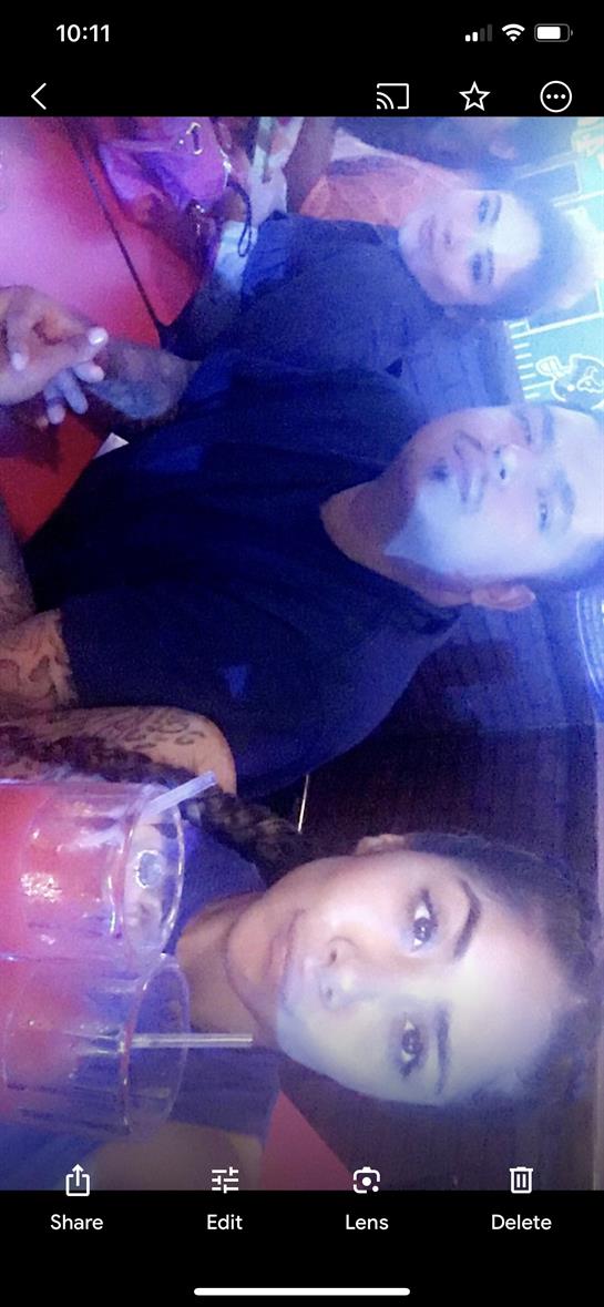 Two friends are seated at a vibrant bar, smiling and enjoying their beverages in a fun atmosphere.