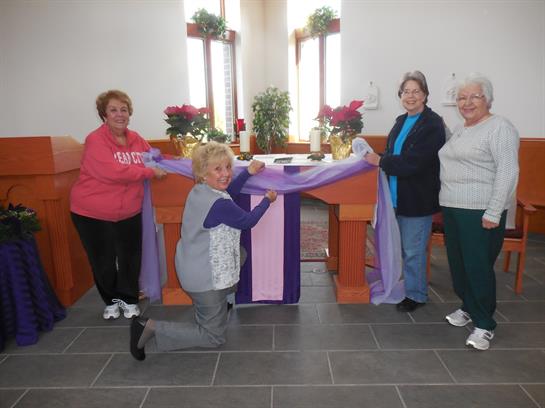 A group of women standing around a table