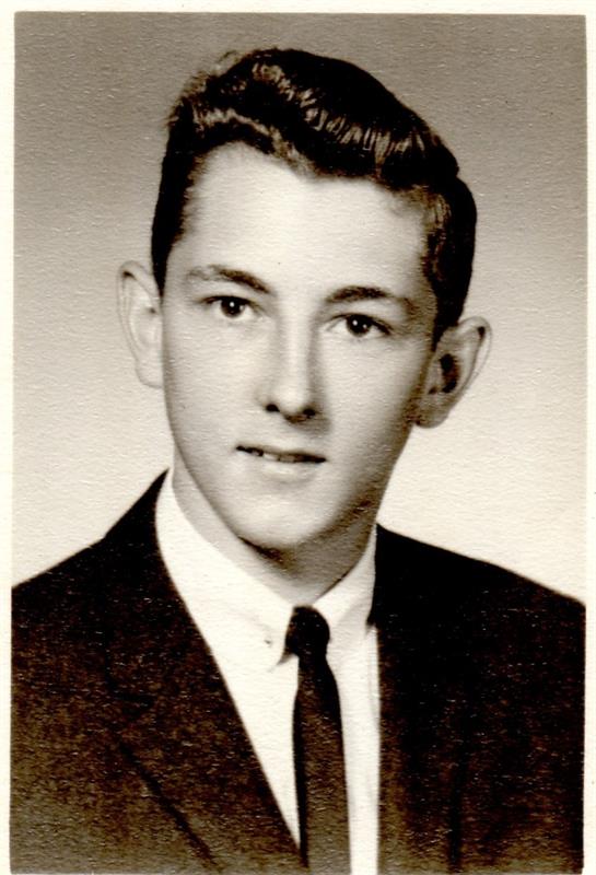 Young man with styled hair wearing a formal shirt and tie, captured in a high school portrait.