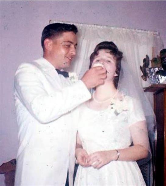 A man feeding a woman a glass of water