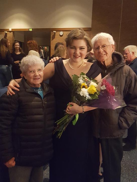 A woman with her arms around a woman with flowers
