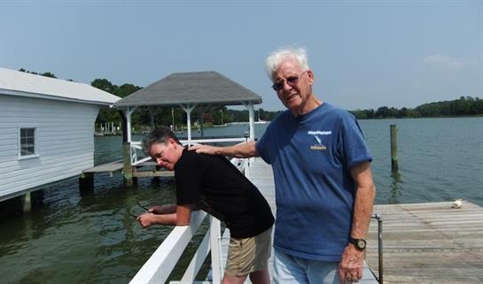 A man standing next to another man on a dock