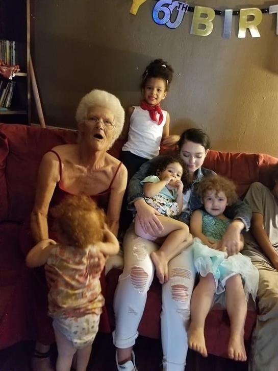 Relatives come together for a 66th birthday celebration while sitting on a comfortable couch.